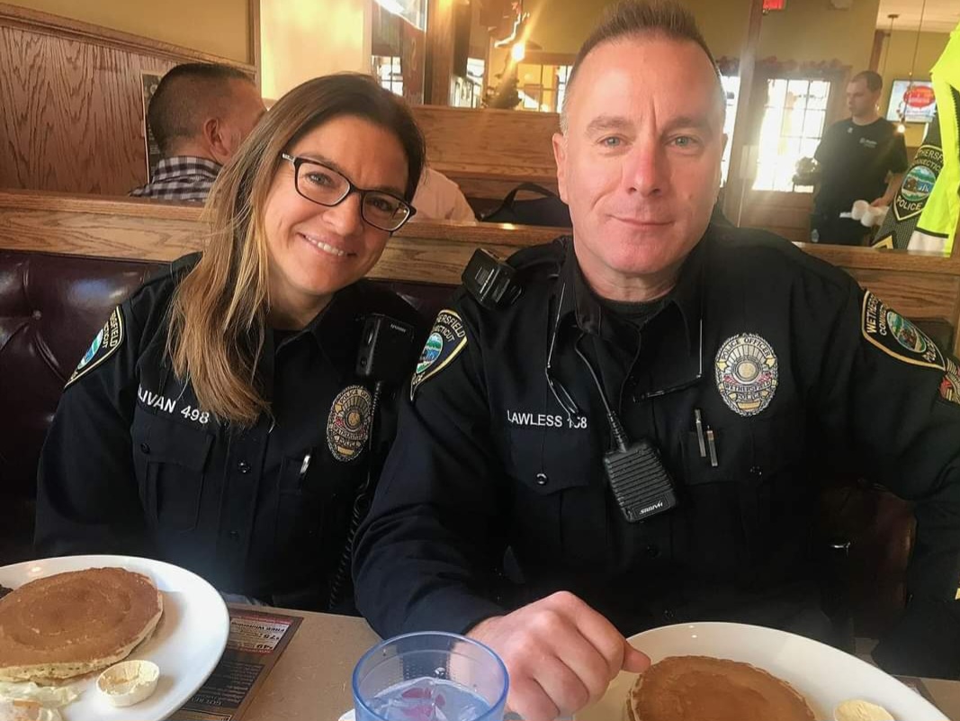 Two police officers and plates with pancakes